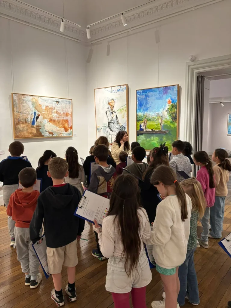 Les élèves de l’École écoutent la guide devant les œuvres du musée Baron Martin